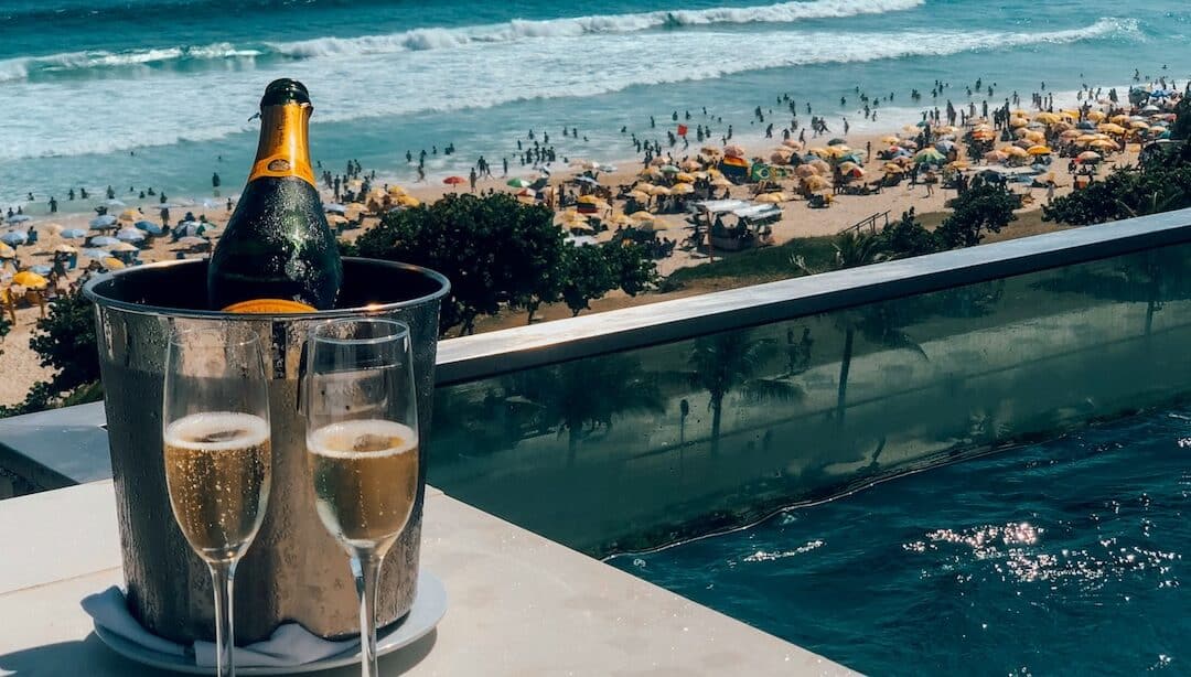 Bouteille et verres de champagne devant la plage